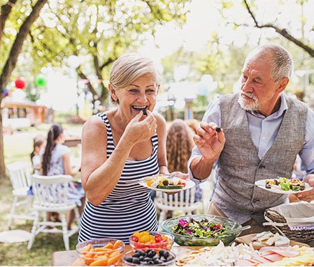 woman eating health food at an outdoor family celebration
